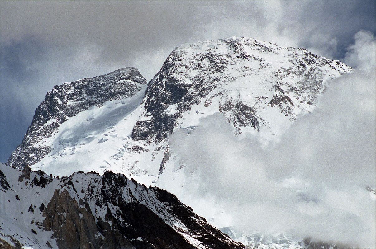 35 Broad Peak Central And Main Summits From Baltoro Glacier Between Goro II and Concordia Broad Peak (8047m) came into view before reaching Concordia. The Central Summit is on the left and the Main summit is on the far right. Its name was originally set as K3, right after the famed K2. But when Sir Martin Conway saw the peak in close detail, with its summit over a mile long, he named it �Broad Peak� which has stuck to this day. The first ascent of Broad Peak was completed by Marcus Schmuck, Fritz Wintersteller, Kurt Diemberger, and Hermann Buhl on June 9, 1957. This extremely small expedition marked a major step forward in the development of Himalayan climbing. Diemberger: �[Buhl's] plan was that from base camp onwards there would only be climbers on the mountain; they would do everything, load-carrying, establishment of camps and, finally, the assault on the summit. And it was all to be done without the use of oxygen.� Diemberger reached the summit just as Marcus Schmuck and Fritz Wintersteller started their descent. As Diemberger was descending from the summit he met Buhl still ascending. �Slowly, with all that incredible strength of his will, he started to move, very slowly, upwards. ... Two men were standing on a peak, still breathing heavily from the ascent, their limbs weary - but they did not notice it; for the all-enveloping glory of the sun's low light had encompassed them too. Deeper and deeper grew the colours. ... No dream-picture, this. It was real enough, and it happened on the 26,404-foot summit of Broad Peak.� � Summits And Secrets by Kurt Diemberger.